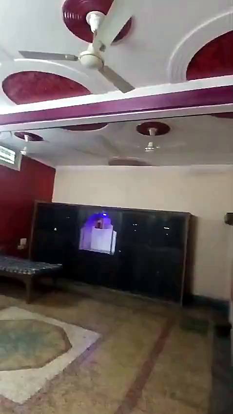 A decorated ceiling with fans, above cupboards and a bed