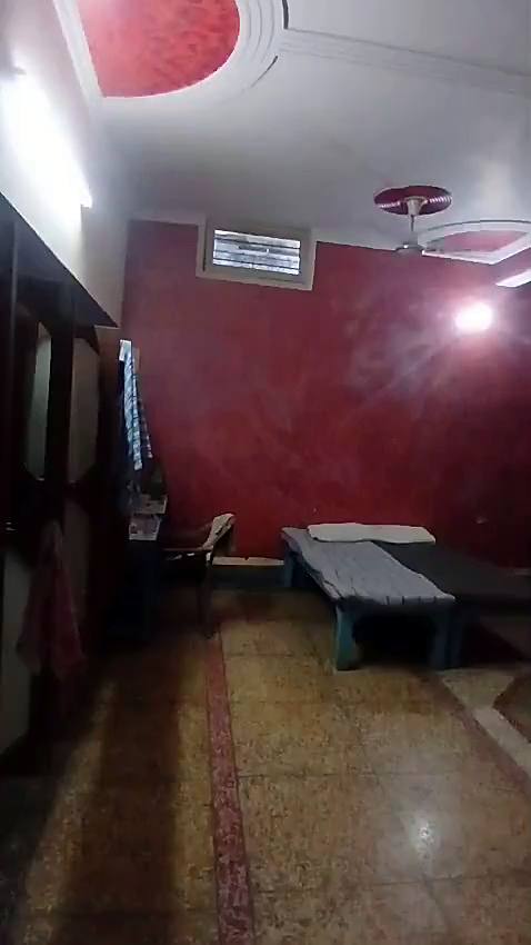 A large room with red walls, beds and ceiling fans