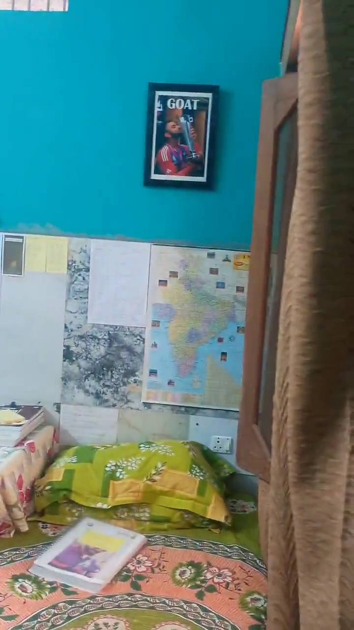 A bed under a wall of posters and a map of India