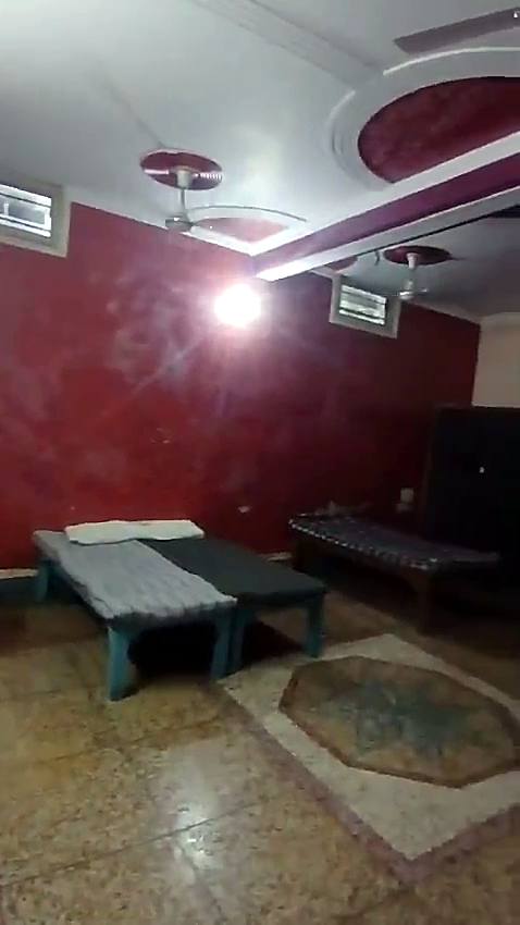 A large room with three beds, red walls and a patterned floor
