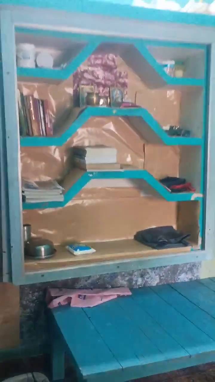 Built-in wall shelves with books, above a wooden bed
